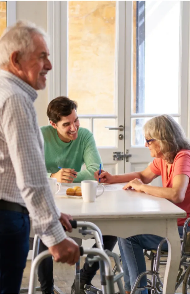 Volunteer chatting and doing an activity with a resident at a table.